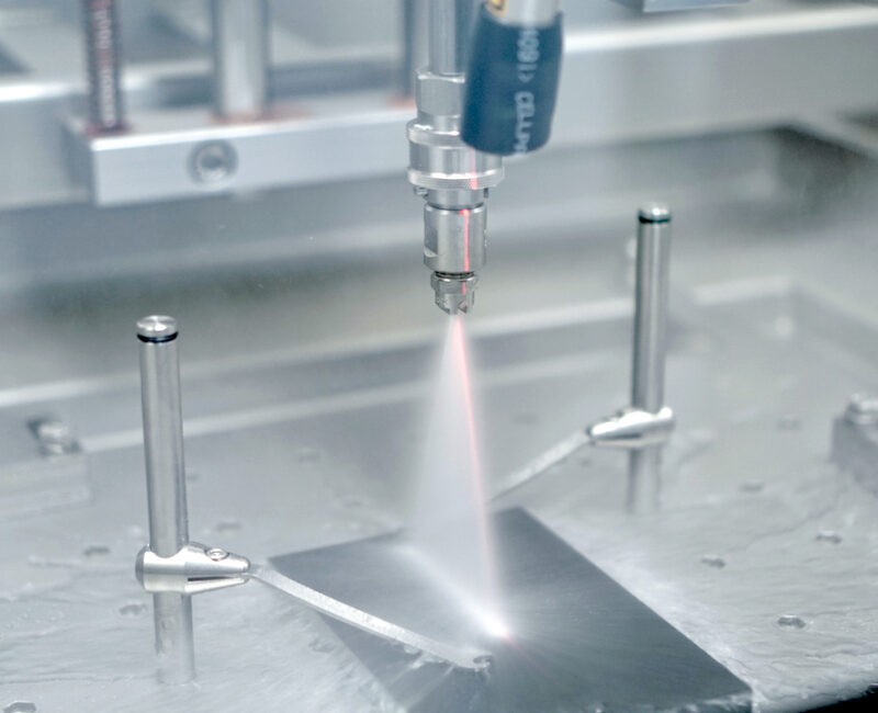 Sprühdüse in der Prüfkammer über einer beschichteten Aluminiumprobe