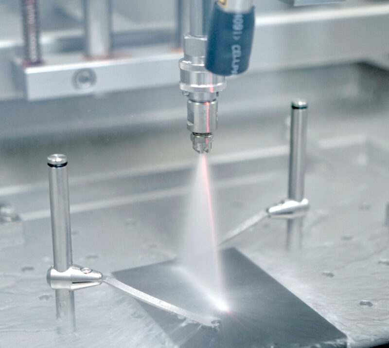 Sprühdüse in der Prüfkammer über einer beschichteten Aluminiumprobe