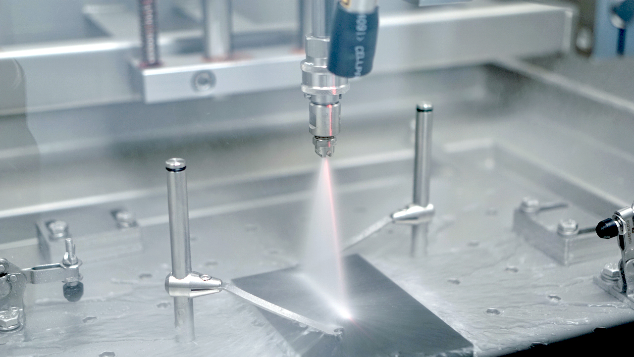 Sprühdüse in der Prüfkammer über einer beschichteten Aluminiumprobe
